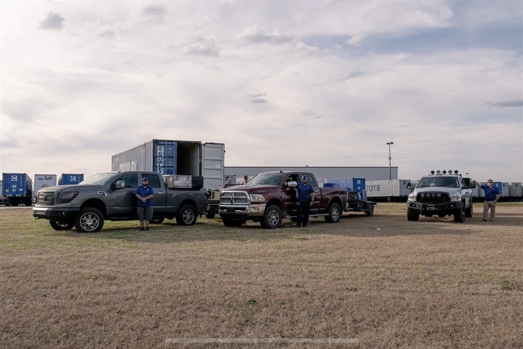 Current JTR team beside three mobile service trucks